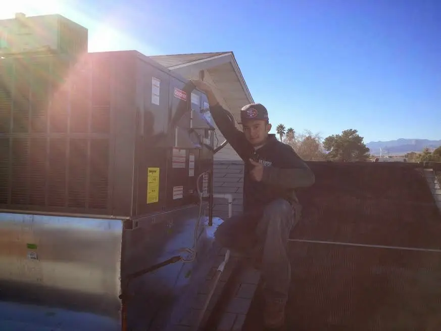 HVAC technician performing AC Tune-Up on a rooftop unit in Fort Myers